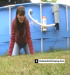 A woman speaks to the camera then takes a dump in the grass next to a pool.